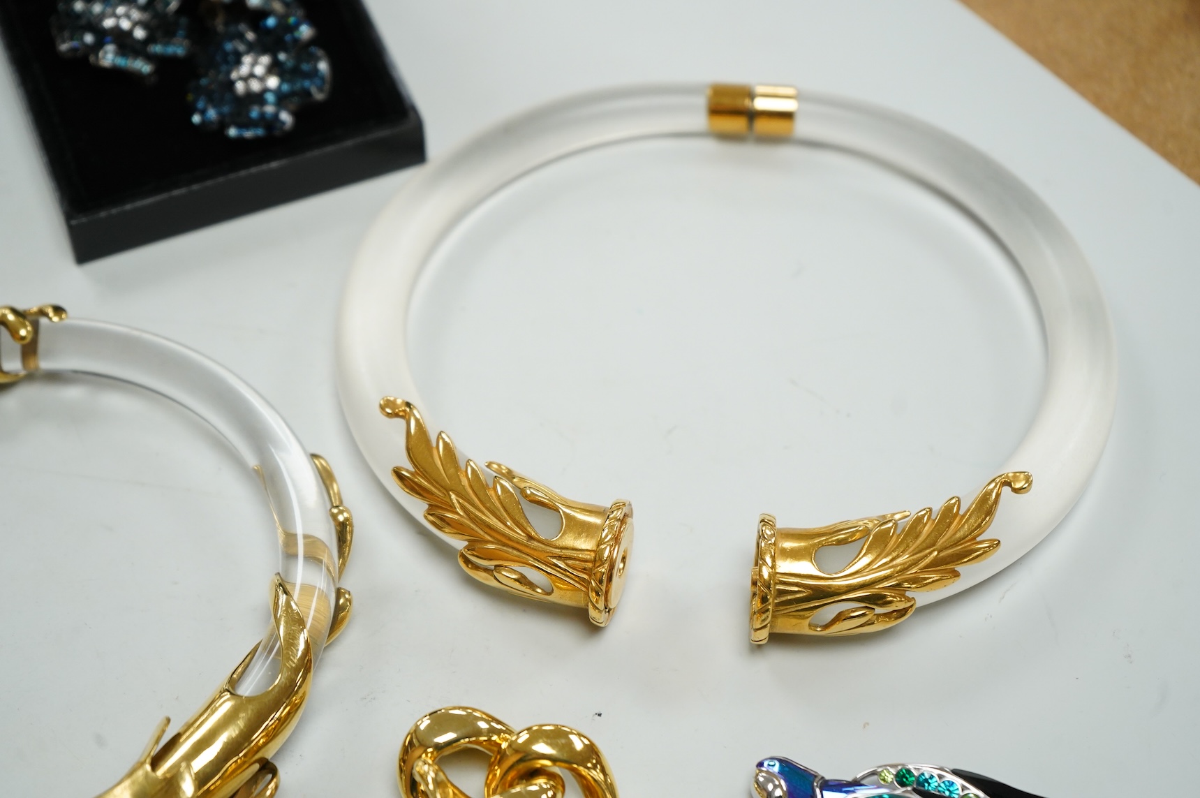 A small group of assorted costume jewellery including a 925 and paste set brooch and pair of ear clips and a gilt metal charm bracelet.